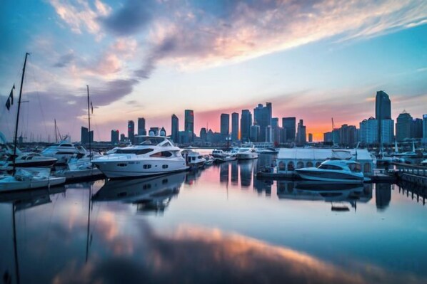 A marina with boats and a city skyline in the background.