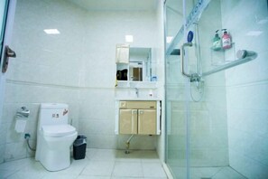 A compact bathroom with a toilet, sink, and shower. - Tujia Sweetome Vacation Rentals (Middle Xianggang Road Lijing Yuzhu) (Qingdao)