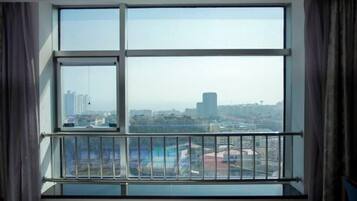 A room with a large window offering a city view.