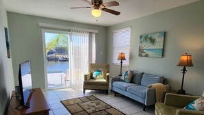 A living room with a television, two couches, a chair, a coffee table, and a ceiling fan. - Hudson oh beautiful Hudson (Hudson)