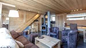 A cozy cabin interior with a wooden ceiling, a fireplace, a sofa, and a dining area. - 70m from ski slopes, Ground floor, balcony, fireplace or stove, tv, ski locker, 74m², La Clusaz (La Clusaz)