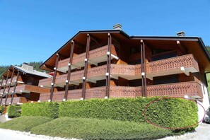 A multi-story wooden building with balconies, likely a hotel or resort. - 250m from ski slopes, Ground floor, terrace, tv, ski locker, 28m², La Clusaz (La Clusaz)
