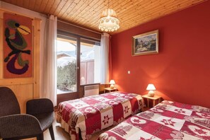 A cozy room with two beds, wooden ceiling, a painting, and a window with a view of snow-covered mountains. - 250m from ski slopes, Ground floor, terrace, tv, ski locker, 28m², La Clusaz (La Clusaz)