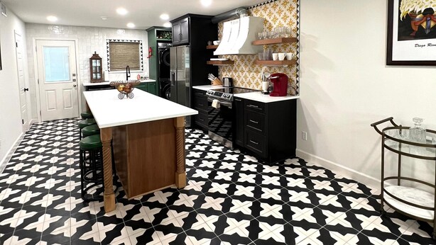 A kitchen with a black and white patterned floor, a wooden island, and black cabinets. - Frida Unit #2. Charming 2-bedroom apartment  in delightful Corpus Christi. (Corpus Christi)