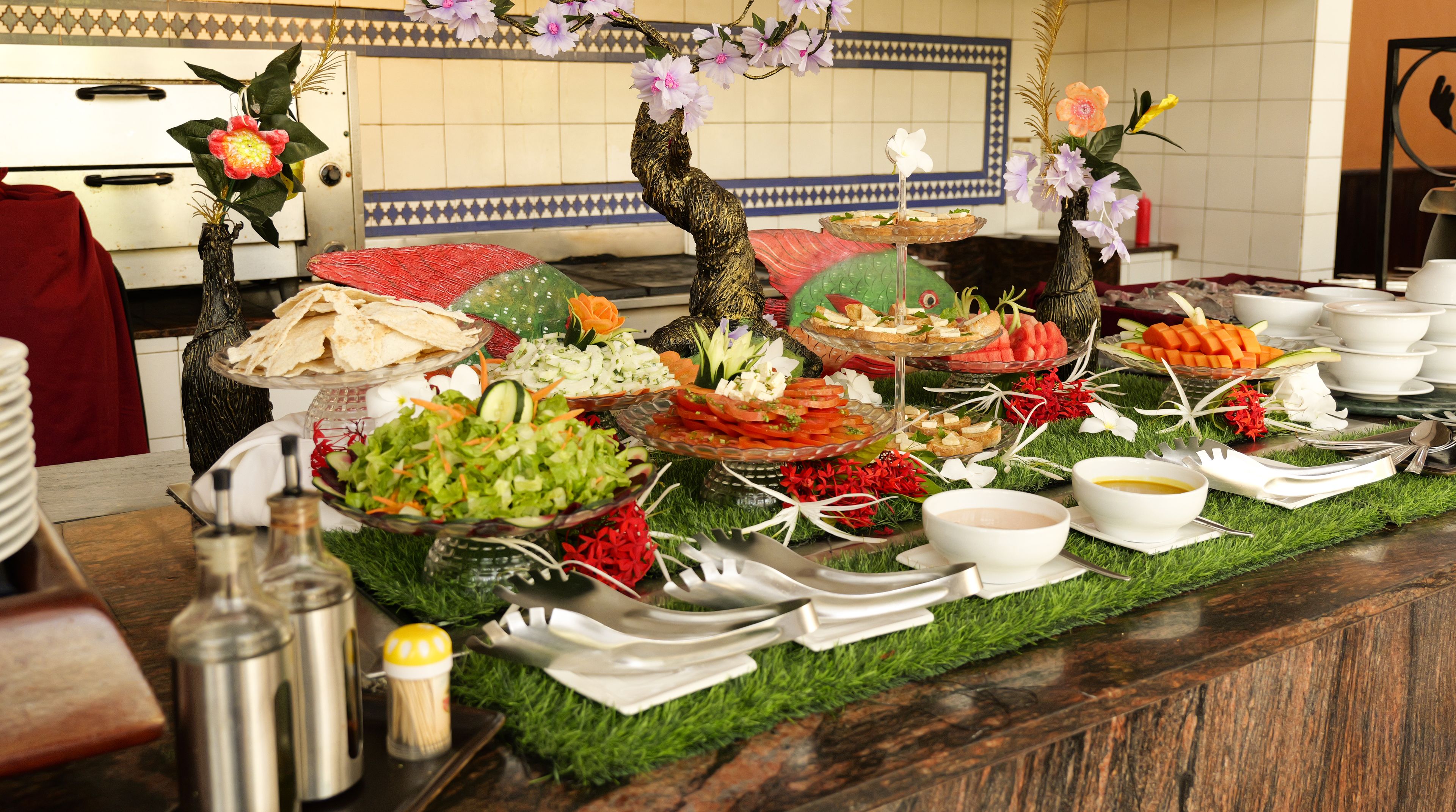 A buffet table with various food items and a decorative centerpiece.