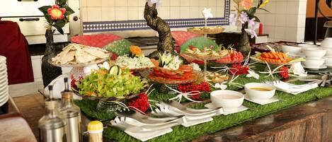 A buffet table with various food items and a decorative centerpiece.