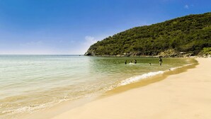 På stranden, hvit sand, strandtelt (inkludert) og solsenger