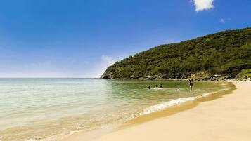 Di pantai, pasir putih, kabana percuma, kerusi lepak pantai
