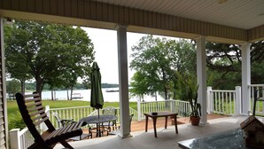 A covered patio with a view of a lake, outdoor furniture, and a potted plant. - Lakehouse on Ky Lake-Lakefront, Park like backyard, Covered Dock, Firepit. (Benton)