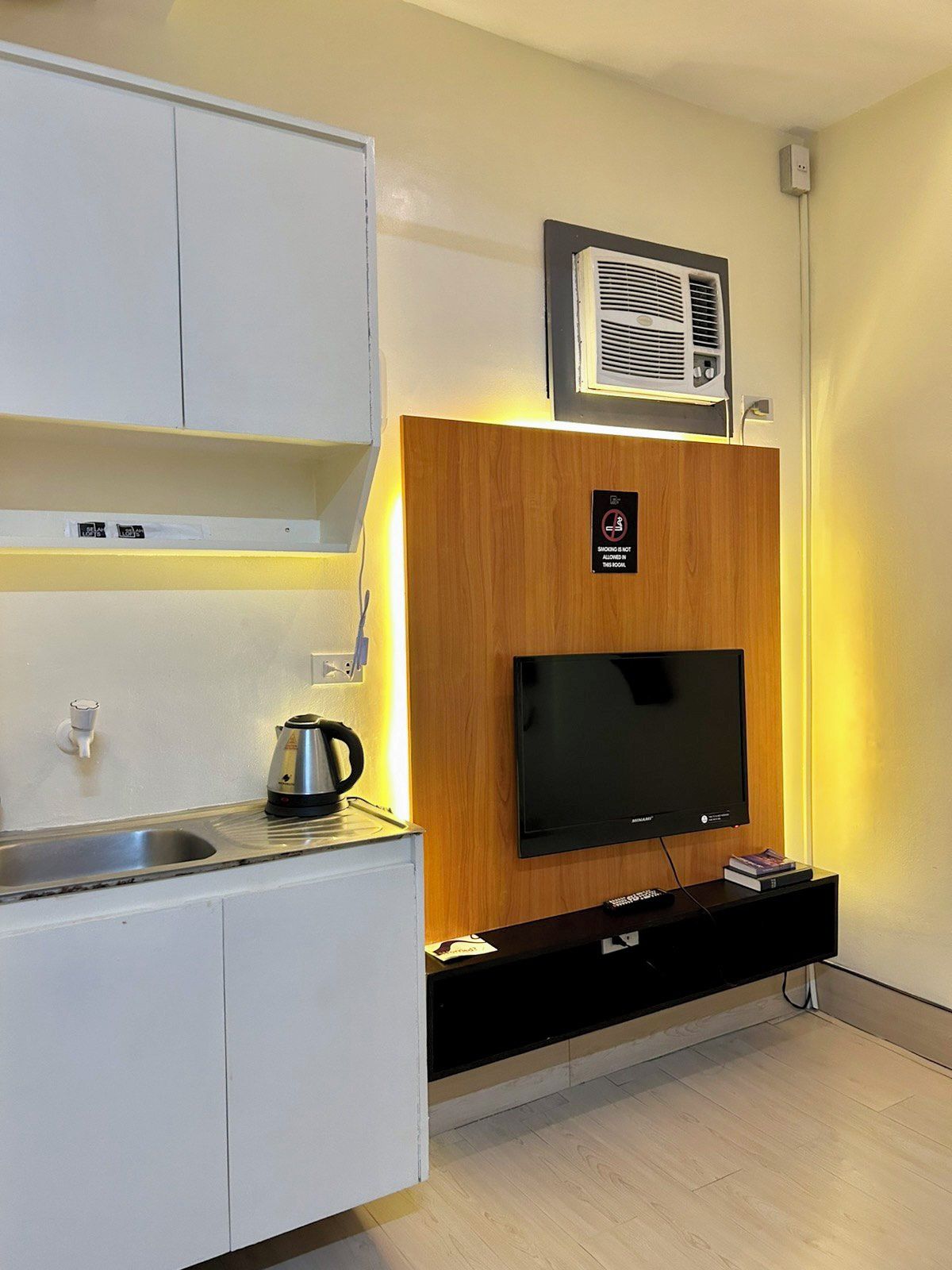 A modern kitchen with a built-in TV, a coffee maker, and a sign indicating no smoking.