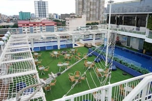 A rooftop terrace with a pool, outdoor seating, and a climbing structure. - Selah Lofts Pasay (Pasay)