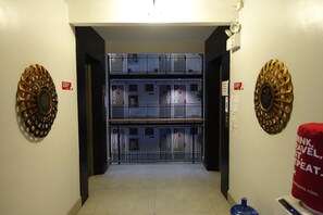 Un couloir avec une double porte qui donne sur une pièce offrant une vue sur le paysage urbain.
