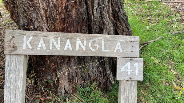 Un letrero de madera con el nombre 'KANANGLA' y el número '41' montado sobre un poste.