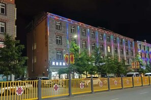 A multi-story building with a traditional architectural style, featuring a series of windows and a visible entrance. - Dongri Yanguang Hotel (Shangri-La)