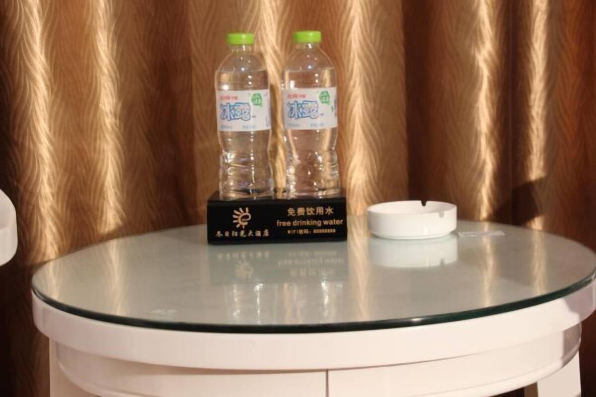 A round glass table with two bottles of water and a cigarette ashtray.