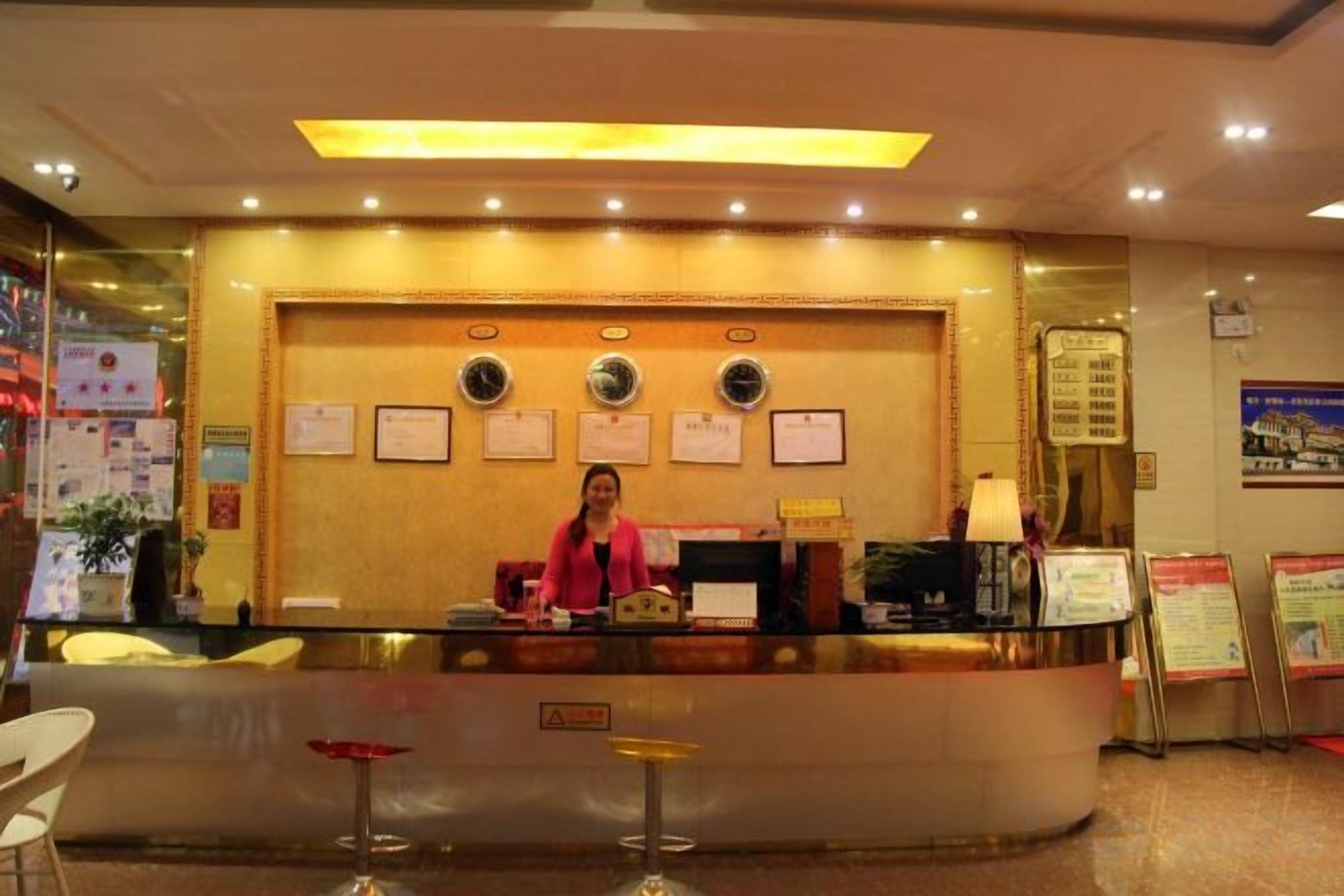 A reception desk with a receptionist, framed certificates on the wall, and a digital screen.