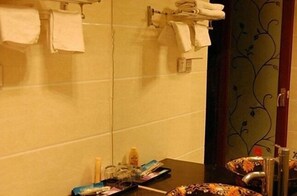 Bathroom features a sink, mirror, and modern faucet, with a decorative panel and towel racks.