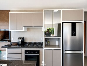 Una cucina moderna con piano cottura integrato, forno e frigorifero in acciaio inossidabile.
