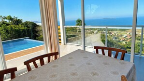 A balcony with a view of the ocean and a swimming pool. - Paraíso do Coral - Vista Mar - Garopaba (Paulo Lopes)