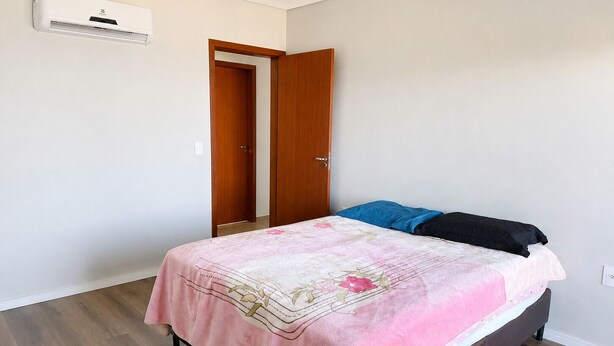 Ein Schlafzimmer mit einem Bett, einem Kleiderschrank und einer Klimaanlage.