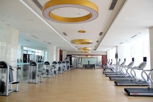 Un gimnasio con cintas de correr, elípticas y equipo de pesas.