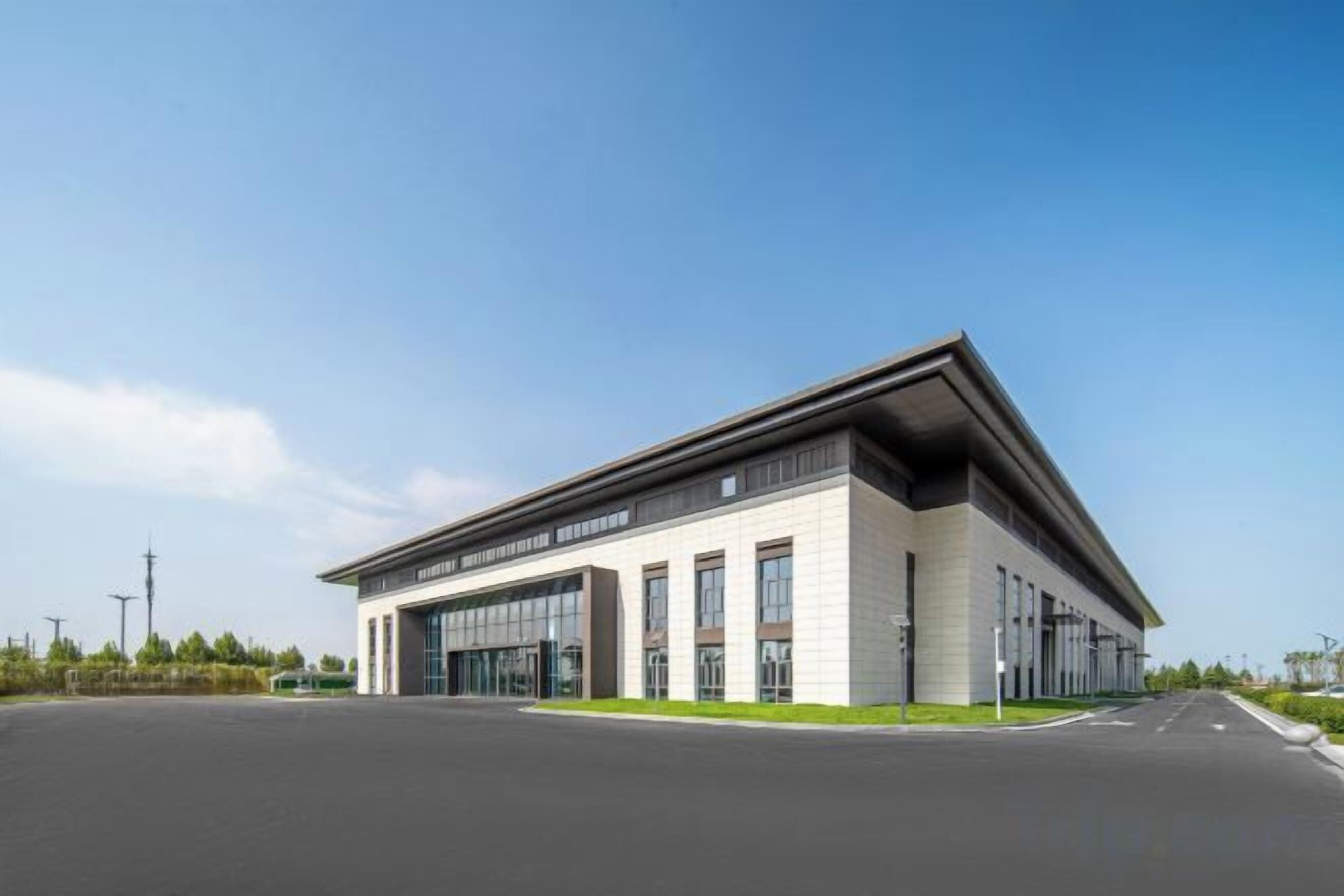 A modern building with a flat roof, large windows, and a wide entrance.