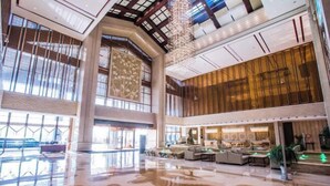 A spacious lobby with a high ceiling, large windows, and a central seating area. - Jinling Haizhou Bayview Conference Center (Lianyungang)