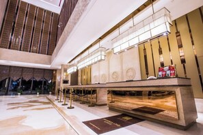 A lobby with a reception desk, a chandelier, and a patterned floor. - Jinling Haizhou Bayview Conference Center (Lianyungang)