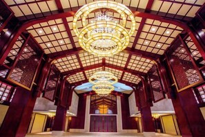 A traditional interior with a high ceiling, ornate wooden lattice, and a central chandelier. - Jinling Haizhou Bayview Conference Center (Lianyungang)