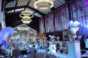 An indoor venue with a stage labeled 'WEDDING' and multiple tables set up for guests. - Jinling Haizhou Bayview Conference Center (Lianyungang)
