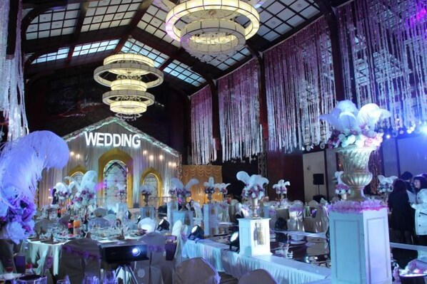 An indoor venue with a stage labeled 'WEDDING' and multiple tables set up for guests. - Jinling Haizhou Bayview Conference Center (Lianyungang)