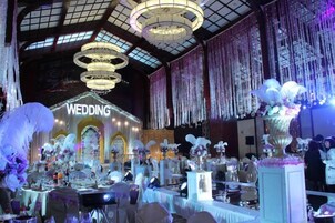 Un espacio interior con un escenario que dice 'BODA' y varias mesas dispuestas para los invitados.