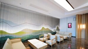 Un vestíbulo moderno con área de descanso, un mural grande y un sofá.