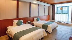 A hotel room with two beds, wooden paneling on the walls, a large window with curtains, and a wooden floor. - Stone Hotel (Yingde)