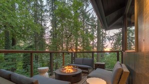 A deck with outdoor furniture, a fire pit, and a view of a forested area. - Forest-View Hot Tub • 5 Min to UO • Game Room (Eugene)