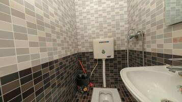 A bathroom with a toilet, bidet, and sink.