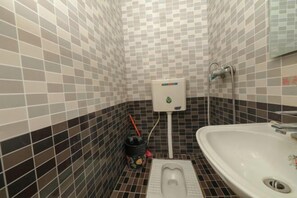 Egy fürdőszoba, amelyben WC, bidé és mosdókagyló található.