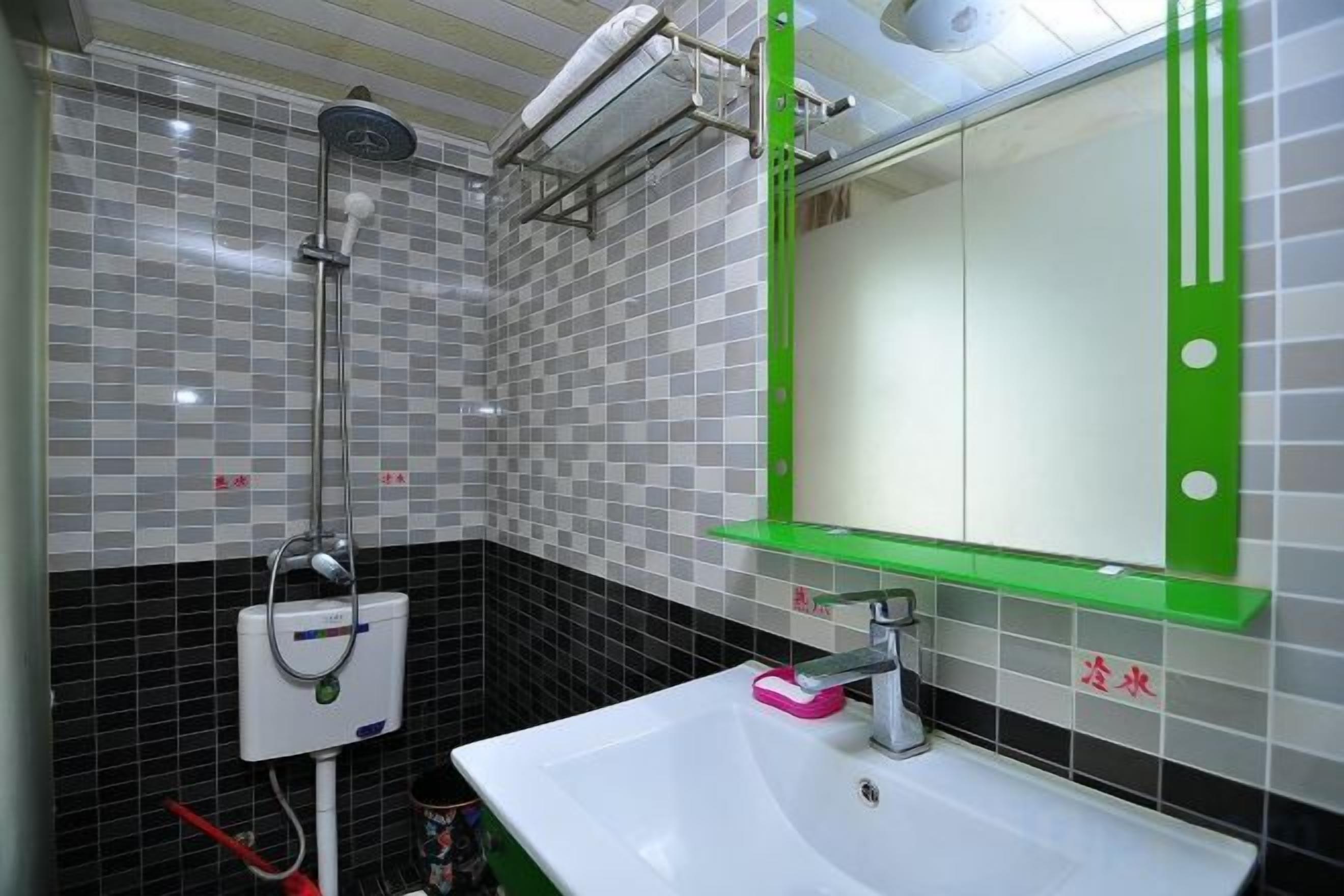 Een badkamer met een wit wastafel, een spiegel met een groene lijst, en een douche.