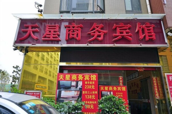 A storefront with a prominent red sign indicating a business center. - Tianxing Business Hotel (Kunming Luosiwan Store) (Kunming)