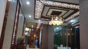Een hotel Lobby met klassieke inrichting, waaronder houten lambrisering en een grote vaas.
