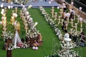 An outdoor event setup with tables, chairs, and floral arrangements. - Yanduhe Hotel (Badong)