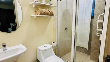 Chuveiro, toalhas de banho, sabonete, shampoo