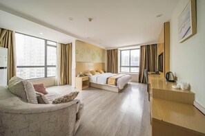 A modern hotel room with a bed, a sofa, a desk, and large windows. - The Wall Street Holiday Hotel (Yichun)