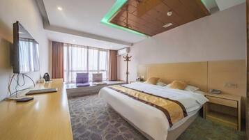 A hotel room with a bed, bedside table, lamp, and a large window.