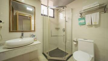 A bathroom with a glass-enclosed shower, a white sink, and a toilet.
