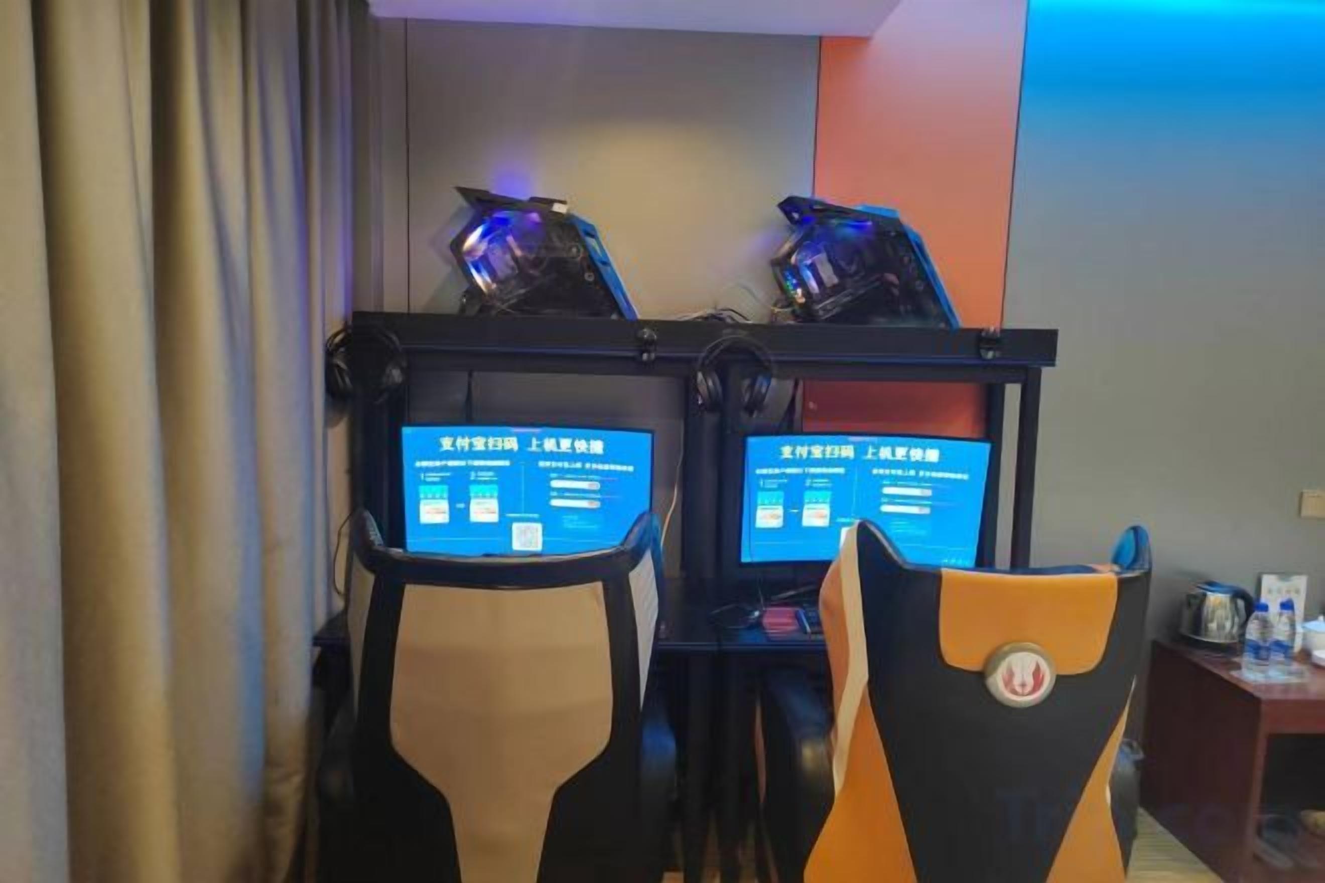 Twee gamingstoelen met digitale displays, een gordijn en een muur met een verticale lichtbalk.