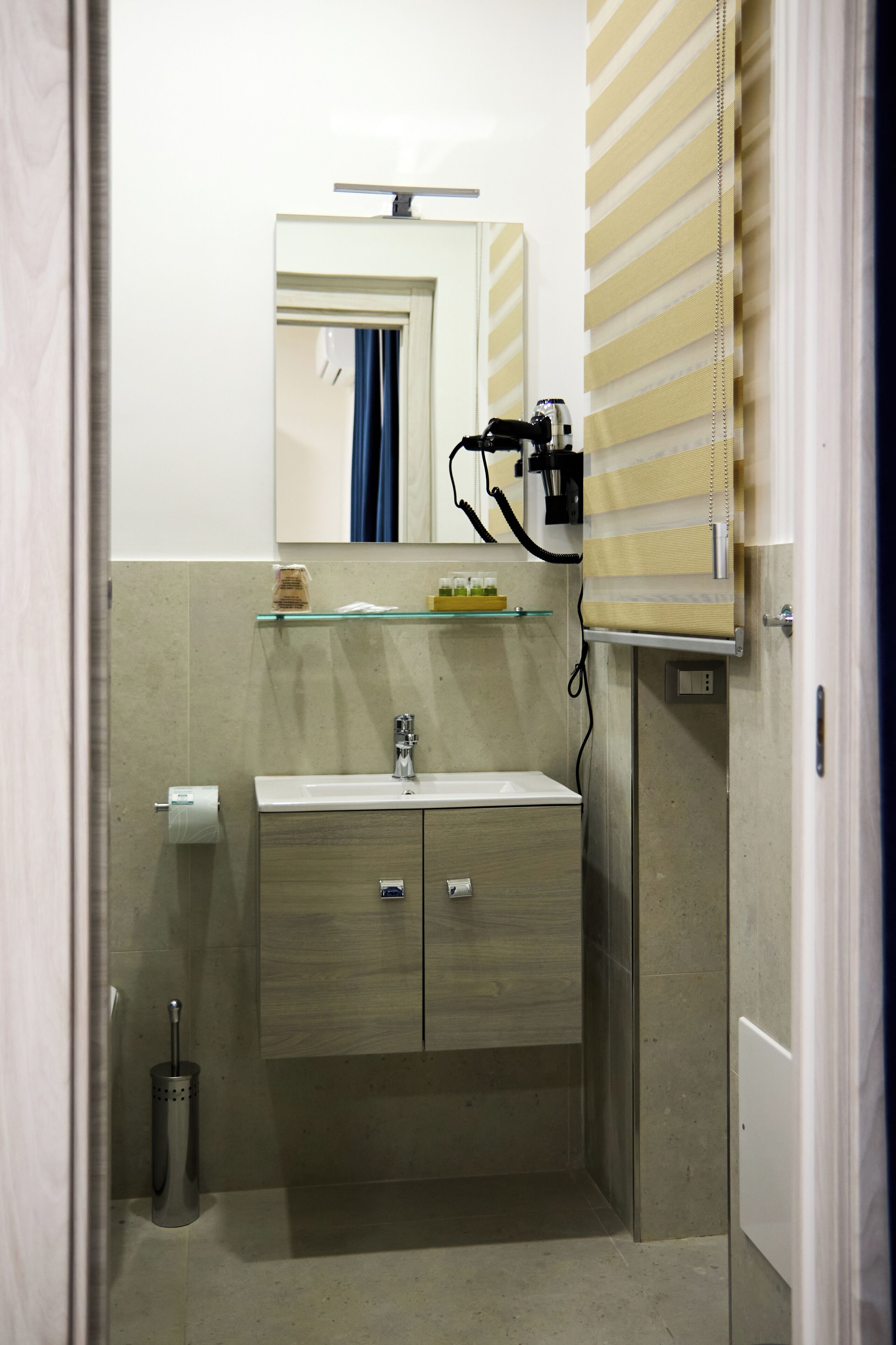 A bathroom with a sink, mirror, towel rack, and a toilet.
