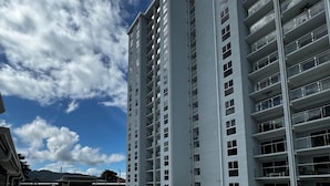 A modern high-rise building with a swimming pool and lounge chairs. - Luxury Condo at Viva Jaco Residence (Jaco)