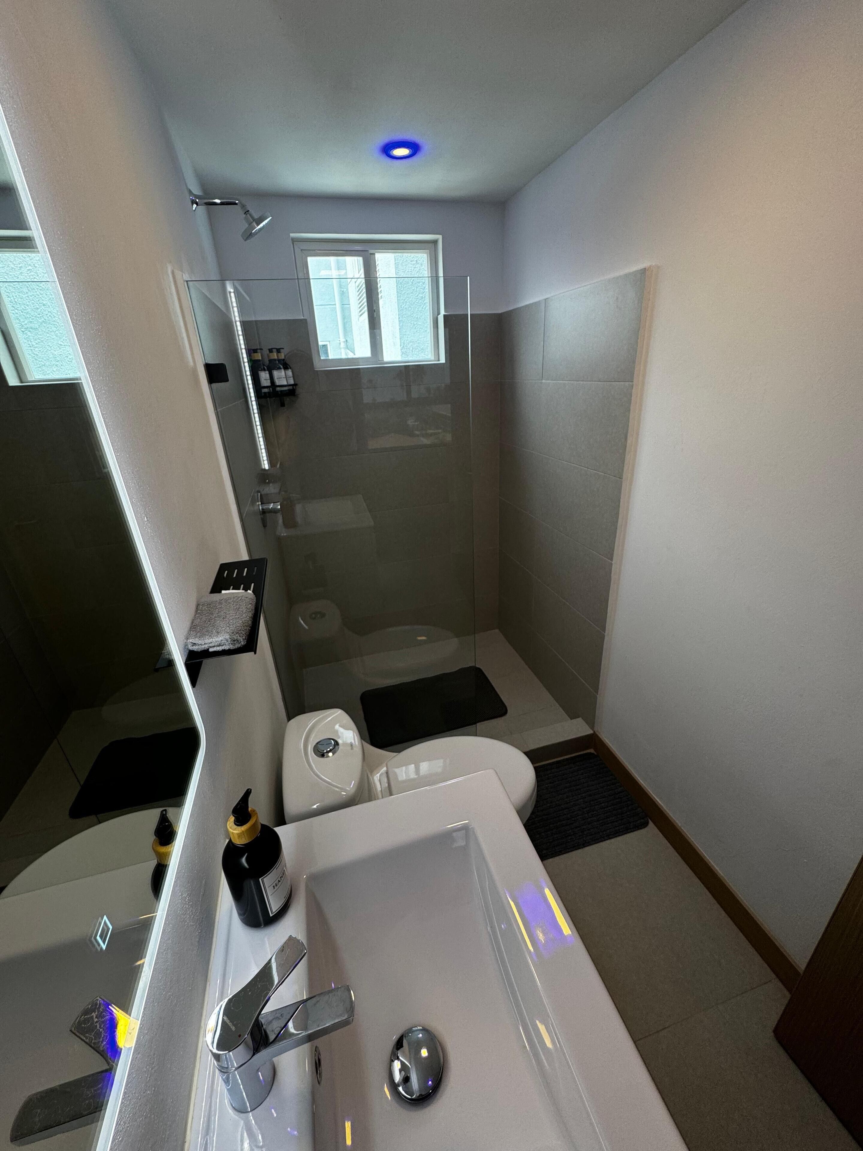 A modern bathroom with a bathtub, toilet, and shower.
