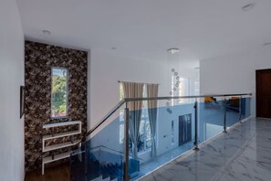A modern interior with a marble floor, a glass railing, a stone wall, and a staircase. - Private Pool Retreat | 4BR | Sleeps 8 | POP (Puerto Plata)